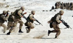 5名士兵白天拿着步枪在白沙滩上奔跑