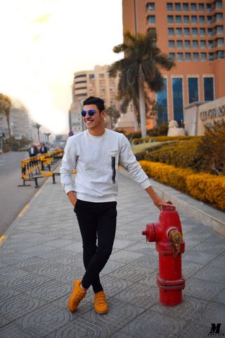 身穿白色长袖衬衫、手持红色消防栓的男子