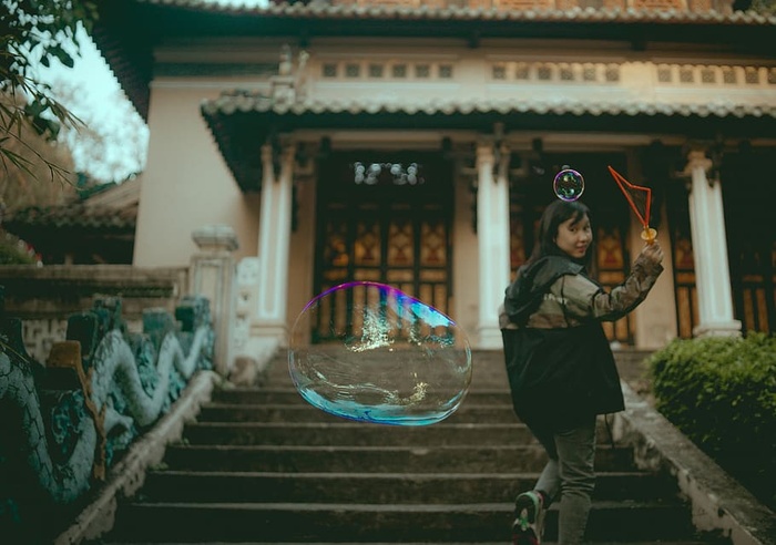 穿着灰色夹克的女人在楼梯上做肥皂泡
