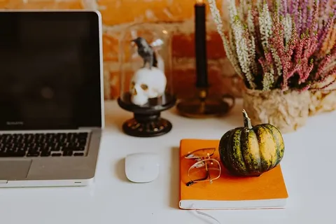 带笔记本电脑和万圣节装饰的桌子