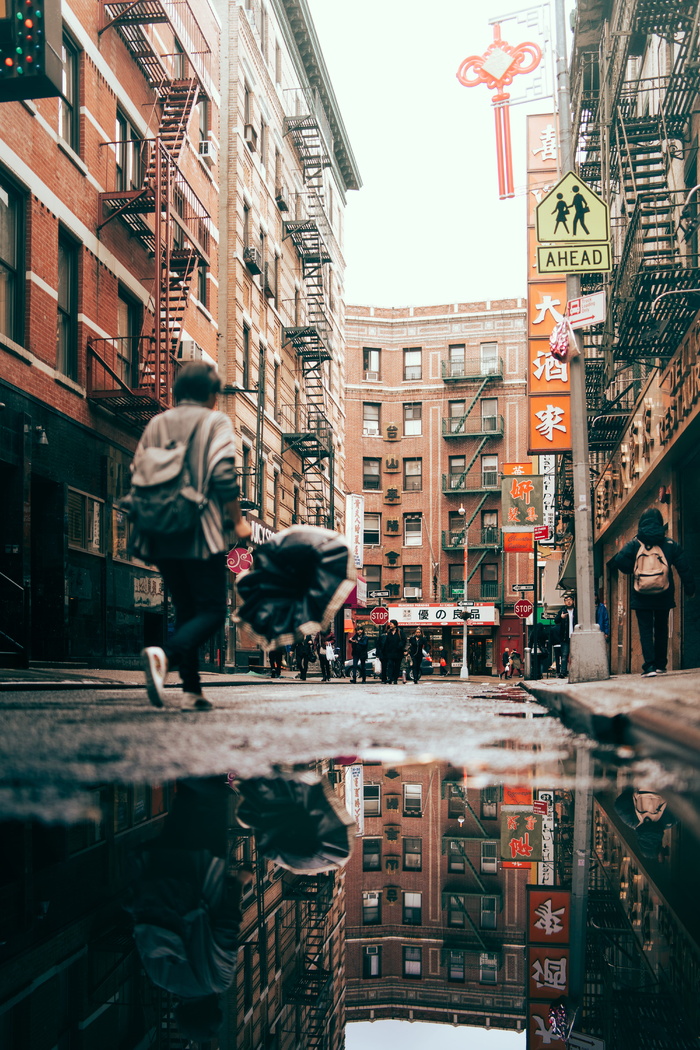 在棕色混凝土建筑附近行走的男子