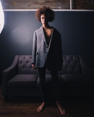 穿着黑色西装站在沙发后面的男人