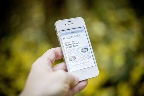 手持白色Iphone 4s的人