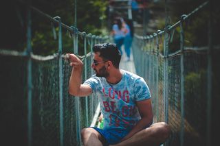 坐在吊桥上的男子