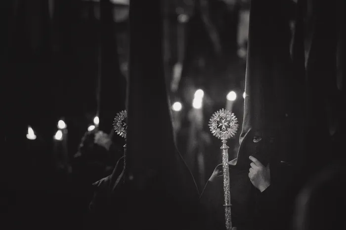戴巴拉克拉瓦拿着魔杖的人的灰度照片