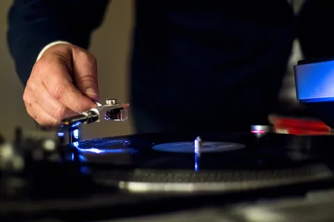 浅焦摄影中手持乙烯播放器的人