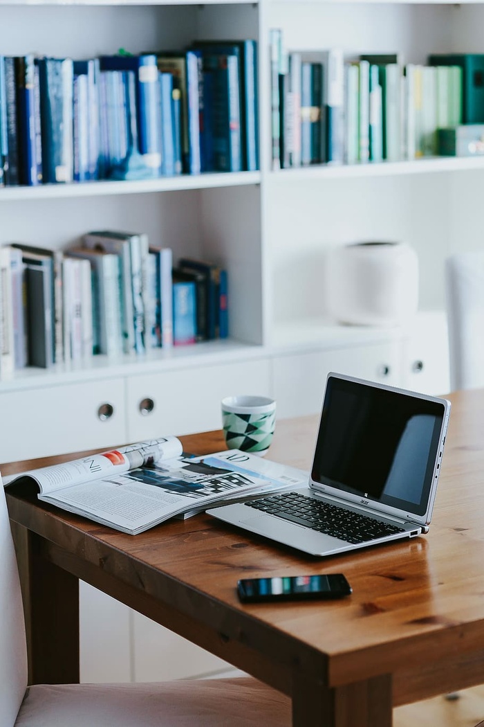 桌上放着各种物品的银色笔记本电脑