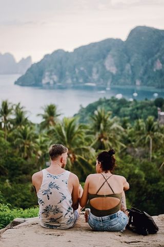 男人和女人坐在丛林附近的岩石上