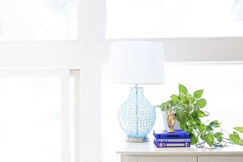 靠近工厂和书籍的餐具柜上的白色台灯