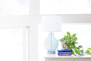 靠近工厂和书籍的餐具柜上的白色台灯