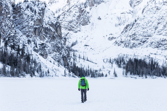 穿绿色夹克的人走向雪山