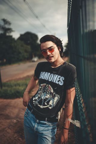 男人靠在绿色的肉篱笆上