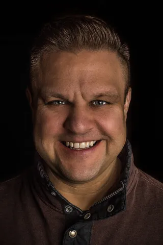 身穿棕色纽扣衬衫的男子微笑着