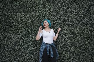 妇女站在灌木丛前的照片