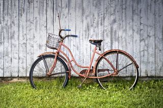 靠墙的粉红色沙滩巡洋舰自行车