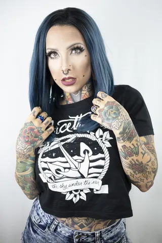 一名女子穿着带有纹身的黑色衬衫的照片