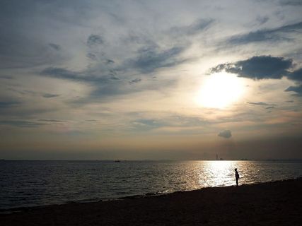 日落时分，海边的海滩上出现了一个人影