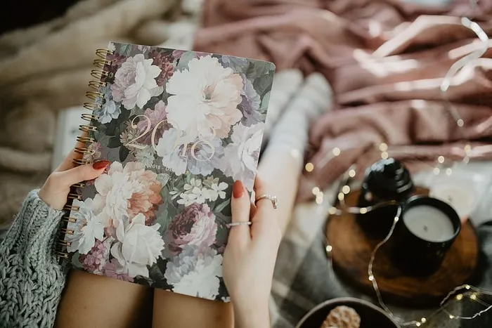 躺在床上的笔记本上写东西，里面有咖啡、蜡烛和姜饼