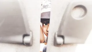 在两个米色靠垫中间看的人