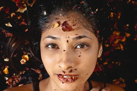躺在干树叶上的女人的照片 躺在干树叶上的女人的照片