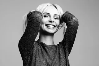 双手捧着头发的微笑女人