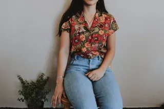 坐在绿色植物旁边椅子上的女人