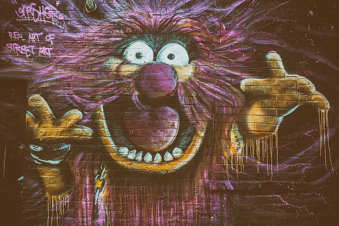 街头艺术，描绘砖墙上捕捉的布偶中的动物角色