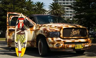 汽车、冲浪板、回复、车辆、海滩、停车场、建筑、棕榈树