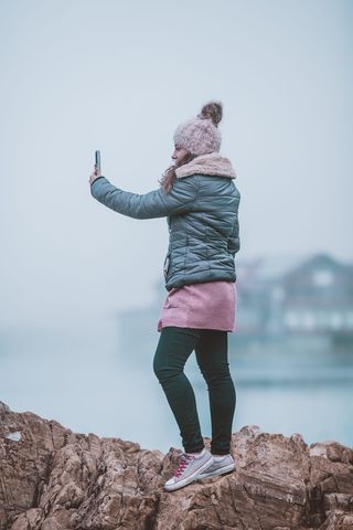 在岩石上自拍的女人