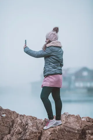 在岩石上自拍的女人
