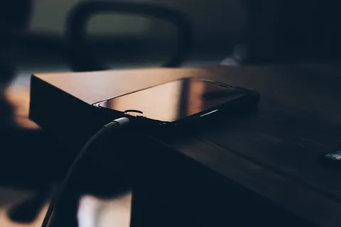 黑色Iphone 7在棕色木桌上的浅焦摄影 黑色Iphone 7在棕色木桌上的浅焦摄影