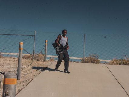 身穿灰色背心和黑色裤子的男子拎包