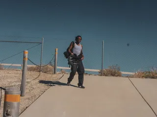 身穿灰色背心和黑色裤子的男子拎包