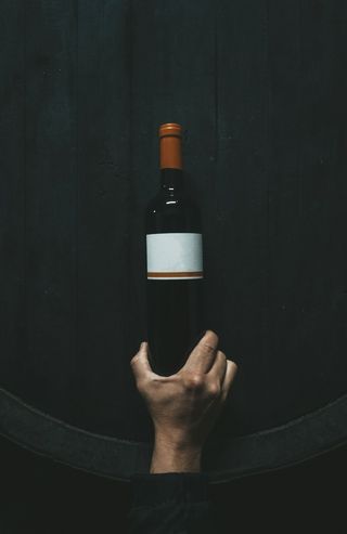 拿着白色标签瓶子的人