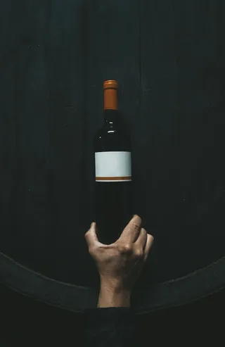 拿着白色标签瓶子的人