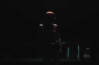 站在空荡荡的停车场附近的女人