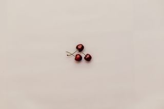 白色表面上的三个红樱桃果实