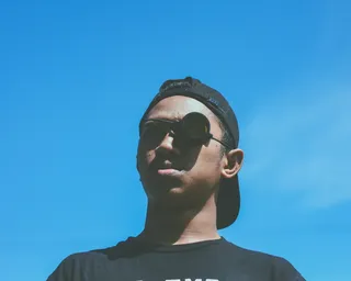 在蓝天下戴着黑色帽子和望远镜的男子