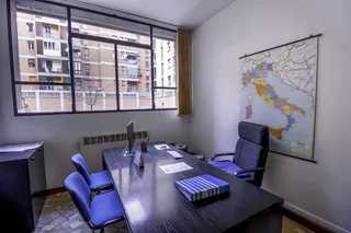 黑色木制书桌旁的黑色滚动扶手椅，带有平板显示器