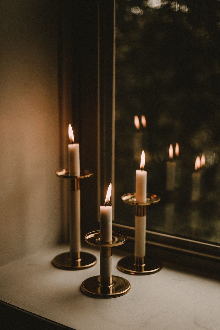 窗台旁有三支亮白色锥形蜡烛