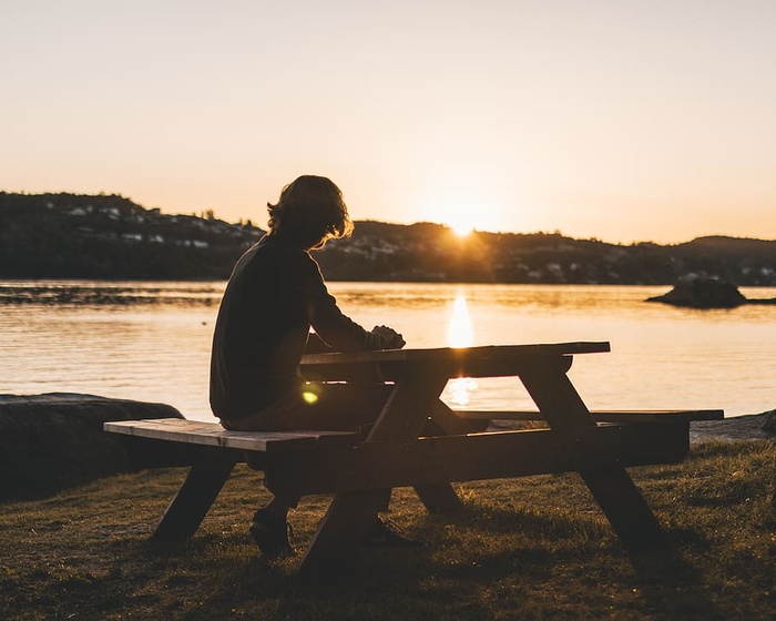 坐在野餐桌上的人的剪影