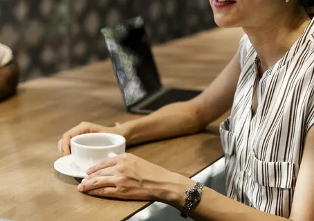 一个女人拿着茶碟上的白色杯子 一个女人拿着茶碟上的白色杯子