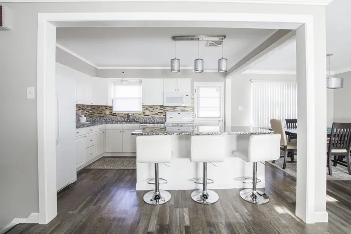 厨房岛前的三个白色酒吧凳