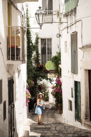 站在被房屋包围的小路上的女人