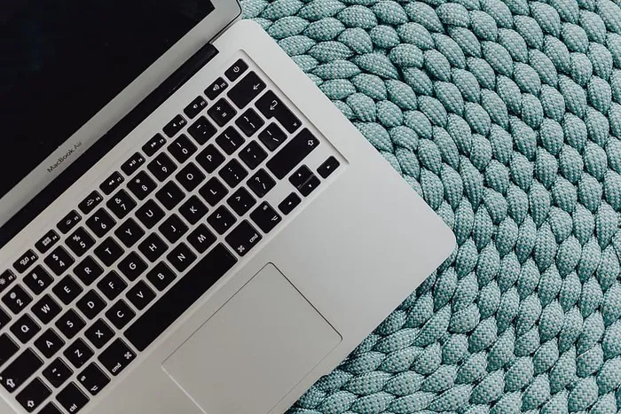 蓝色口袋上的MacBook笔记本电脑