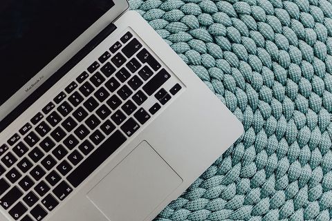 蓝色口袋上的MacBook笔记本电脑