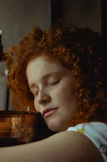 靠在桌子上的卷发女人