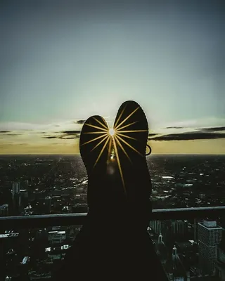 黄金时段，人的脚靠在栏杆上的剪影