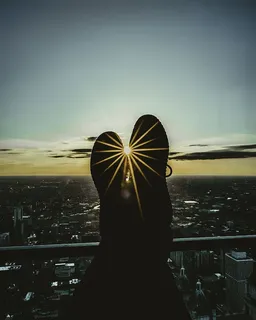 黄金时段,人的脚靠在栏杆上的剪影 黄金时段,人的脚靠在栏杆上的剪影