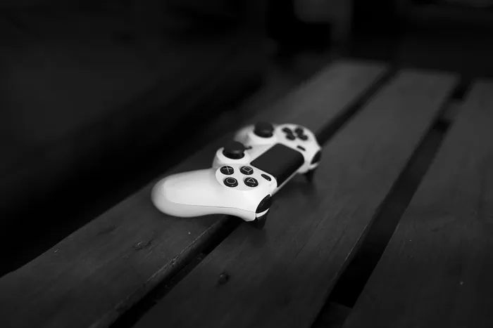 黑色木质表面上的白色Sony Dualshock 4控制器